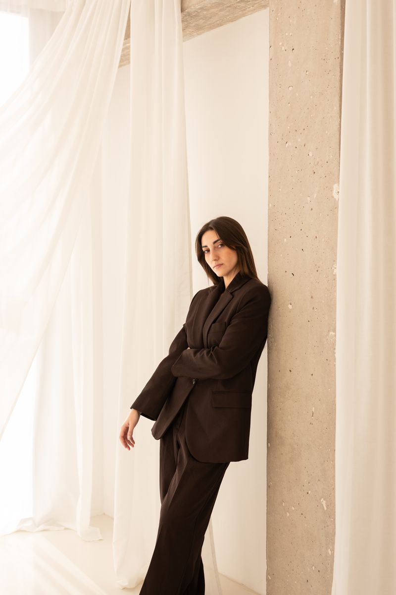 Dennis Rosario, founder of Dalgo Studio, leaning against a column in the studio