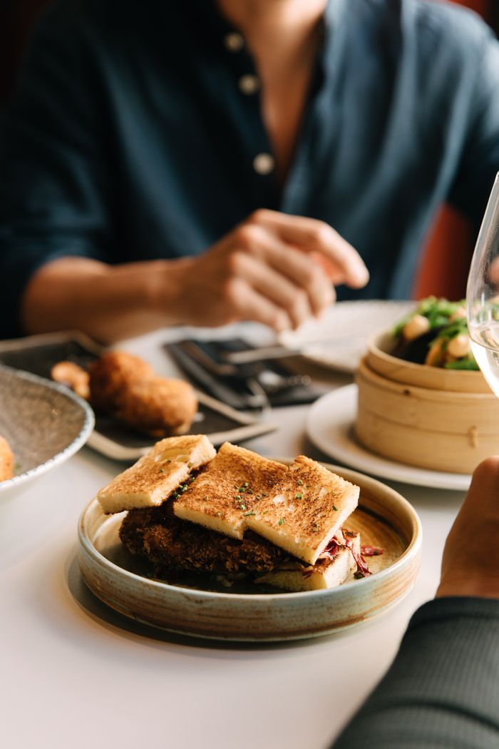 Diner at a table with toasted bread and dim sum