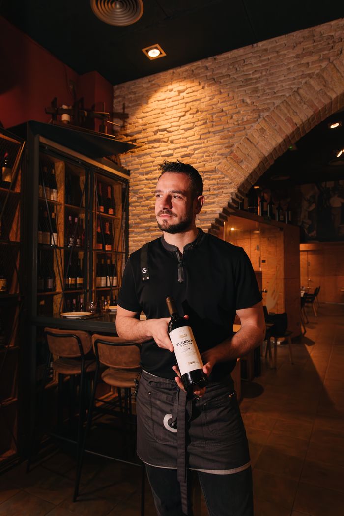 Sommelier holding a bottle of wine in a restaurant cellar